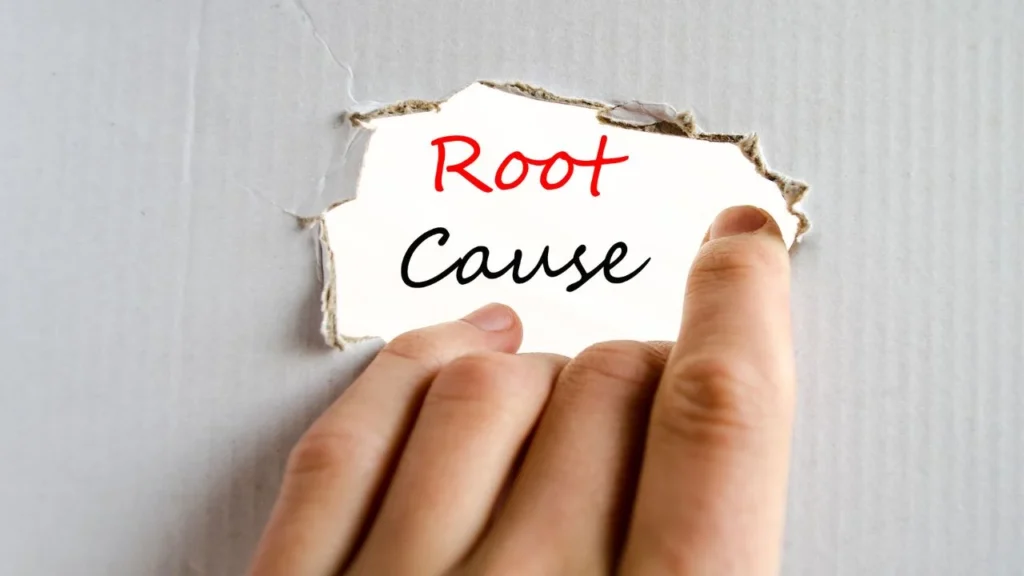 Hole in a piece of paper revealing the words 'root cause'.